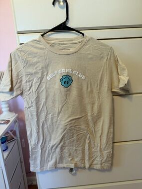 Source Unknown Beige "Self Care Club" Short Sleeve Tee with Teal Logo